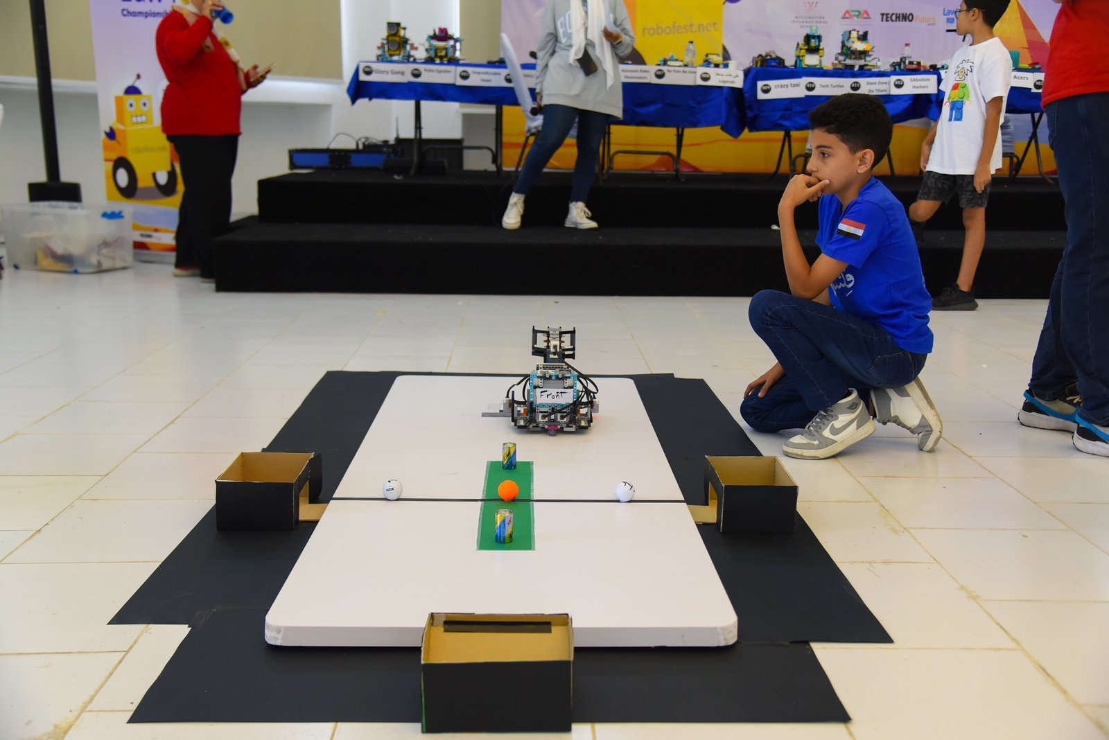 An Ibdaa Academy student preparing a robot during a robotics challenge